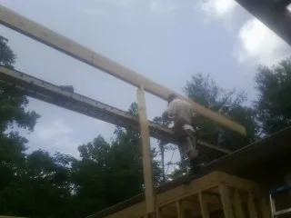 Carpenter setting a ridge beam over a new addition frame — Ice Dam Removal by Roofing Brothers in Mont Vernon