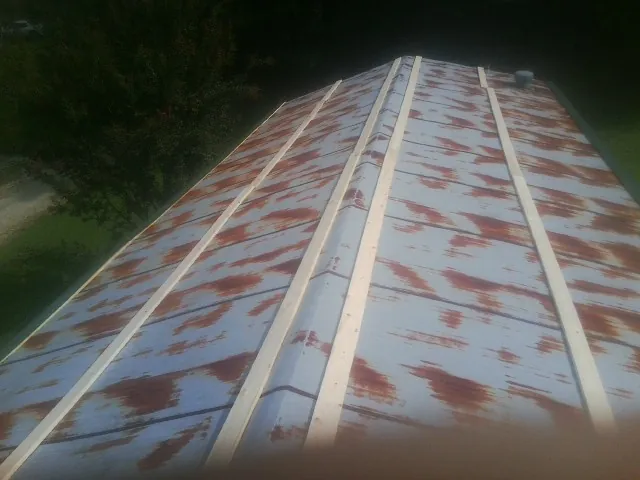Rusted metal roof panels with new wood purlins before replacement — Storm Damage Roof Repair in Mont Vernon by Roofing Brothers