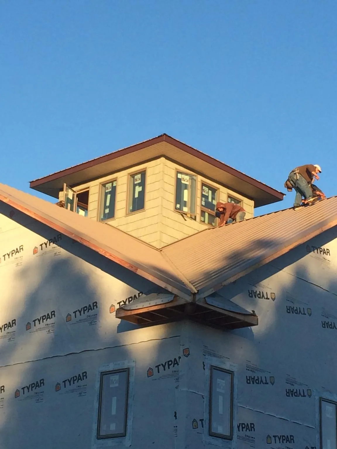 Roofers working around a rooftop cupola on a new metal roof at sunset — Roof Waterproofing in Mont Vernon by Roofing Brothers